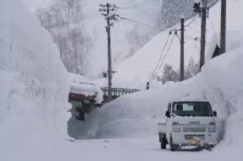 雪が積もる道路と軽トラック