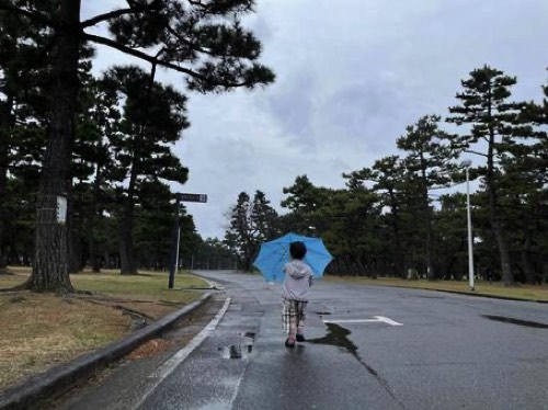 雨上がりの道路と子供