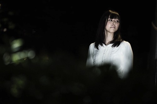 暗闇で周りを見渡す女性