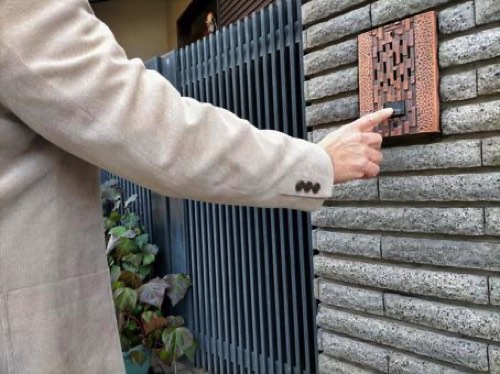 呼び鈴を押す男性