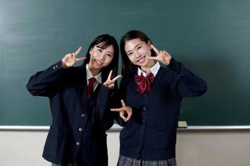 黒板前Vサイン女子高生