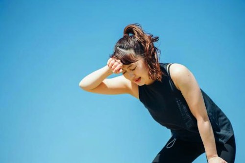 夏のランニングでバテる女性