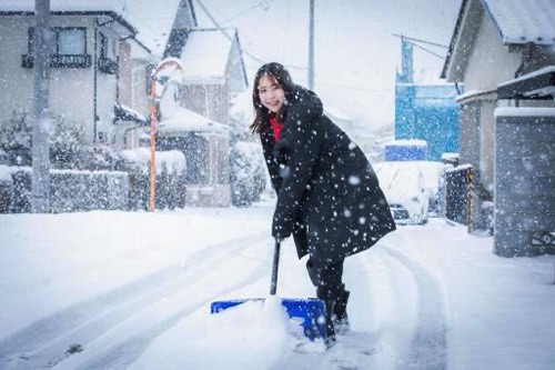 雪よかしをする女性