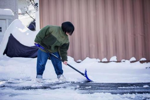 道路の雪かきをする女性