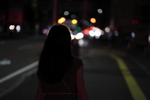 暗い夜道を歩く女性
