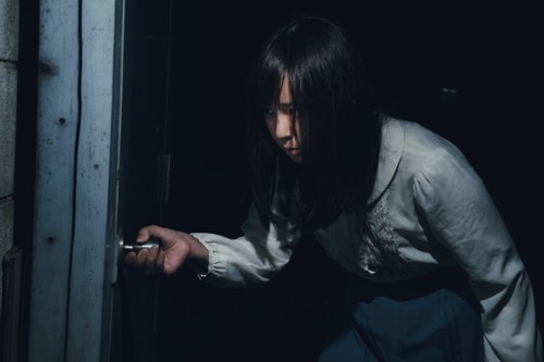 停電時恐る恐るドアを開ける女性