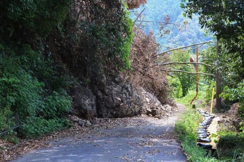 山間の崖崩れで歩道が埋まる