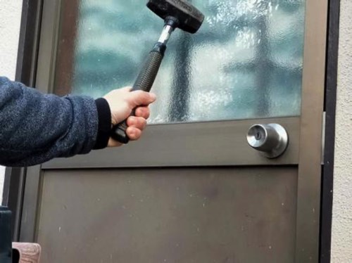 ドアを破壊して侵入を試みる泥棒