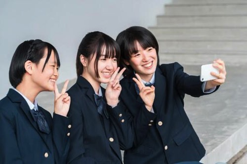 スマホで写真撮影をする中学生