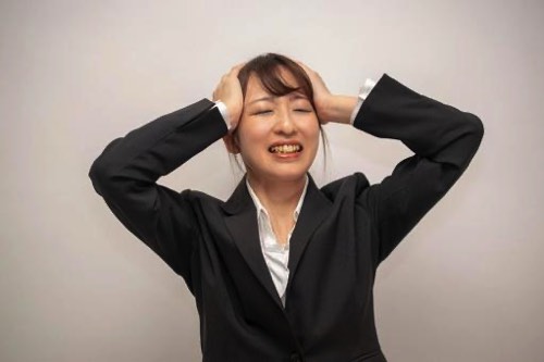 悔しがって頭を抱える女性