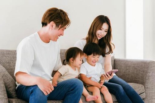 家族でスマートフォンを見る