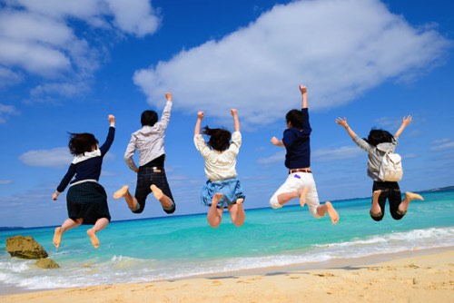 海岸で飛び跳ねる若者